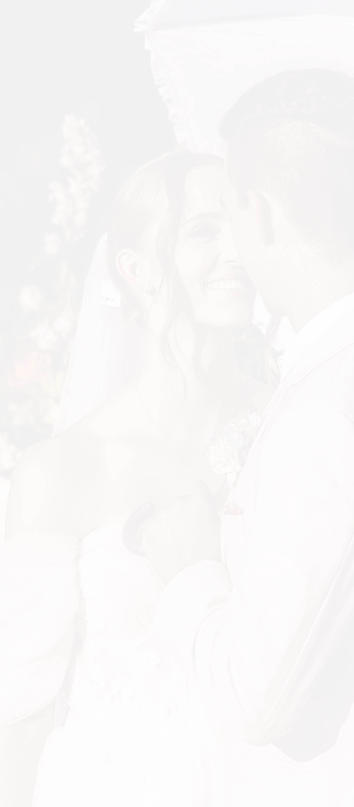 Сouple wearing a white gown and a white suit. Mobile Image